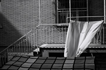 White sheets hanging on the drying rack outside the balcony (Pesaro, Italy, Europe)