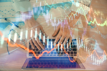 Double exposure of market chart with man working on computer on background. Concept of financial analysis.