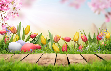 A wooden table top product display with Easter Eggs, pink cherry blossom flowers and tulips...