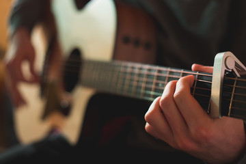 Young man playing on acoustic guitar