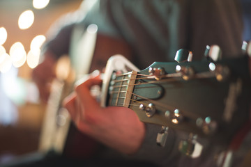 Young man playing on acoustic guitar