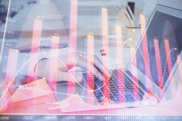 Double exposure of stock market graph with man working on laptop on background. Concept of financial analysis.