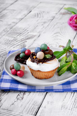 Easter cupcake topped with multicolored marzipan eggs, chocolate nest and marshmallow creme
