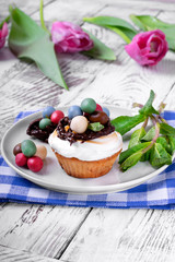 Easter cupcake topped with multicolored marzipan eggs, chocolate nest and marshmallow creme