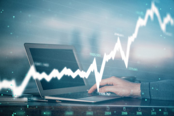 Double exposure of stock market graph with man working on laptop on background. Concept of...