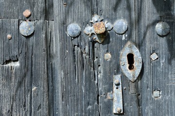 Detail of an old wooden door with nails and keyhole