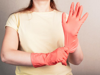 Young Caucasian woman puts on a rubber protective glove