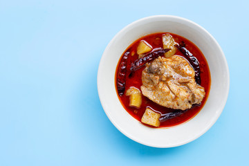 Mussaman curry with chicken and potato on blue background. Copy space