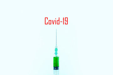green liquid in a syringe on a blue background, concept of Covid-19 injection