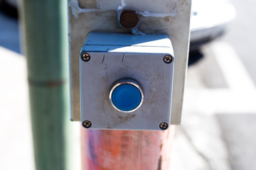 A device with a button for changing the color of the traffic light to green and for crossing the road