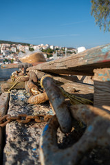 Samos island, pythagorion village with boats. Samos island. Greece. Sea and pythagorion village background. with collorful boats. in the front a big knot and chains