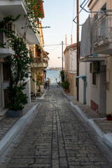 Collorfull narrow street in greece, pythagorion Small street with sea background and green plant. Dreamy with little balconys