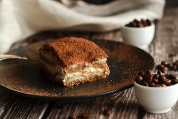 Fototapeta na wymiar Tiramisu cake on a plate. Romantic composition with coffee and other elements