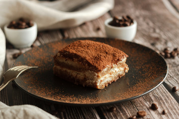 Fototapeta na wymiar Tiramisu cake on a plate. Romantic composition with coffee and other elements
