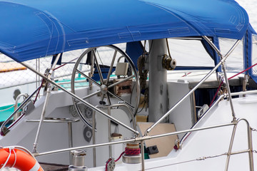 yacht steering wheel under blue awning