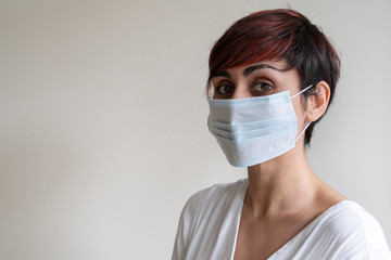 Portrait of young doctor wearing a disposable face mask covering possible germs in mouth. Prevent contagious viral diseases like corona virus covid 19. Stop propagation and use caution measures.
