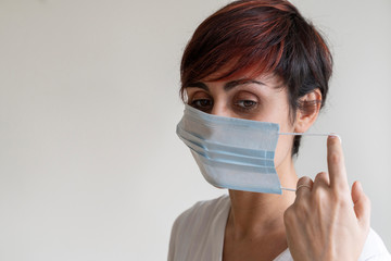 Portrait of nurse explaining steps of wearing a face mask covering possible germs in mouth. Prevent contagious viral diseases like corona virus covid 19. Stop propagation and use caution measures.