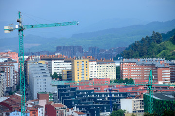 Obraz premium Gruas de la construcción con vista de edificios detras