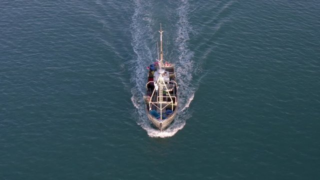 Fishing Vessel in the Early Morning Heading out to Sea