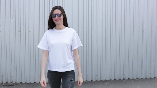 Skinny woman wearing white blank t-shirt and black jeans with space for your logo or design in casual urban style 