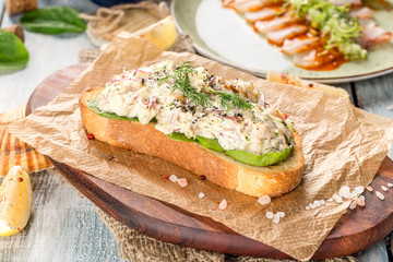 Sandwich with pate and fresh salad on paper and blackboard