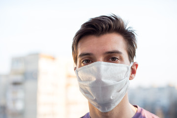 A young guy of European looking wears a medecine mask