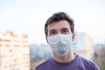 A young guy of European looking wears a medecine mask