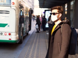 Man wearing FFP3 face protection mask, since new coronavirus Sars-CoV-2 and a flu have emerged waiting at the city bus.