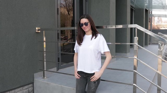 Skinny woman wearing white blank t-shirt and black jeans with space for your logo or design in casual urban style 