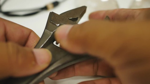 Hand close-up of The repairman is adjusting the width of the wrench.