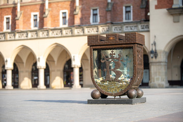 Piggy bank on the background of the Cloth Hall. Main Market Square in Krakow