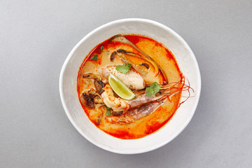 tom yam, shrimp and fish in tomato sauce with herbs and lime , seafood soup