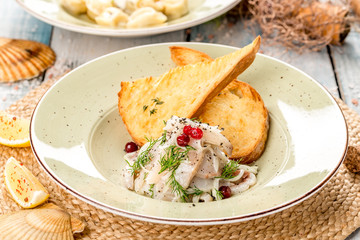 Salted fish salad with cranberries and herbs, served with bread