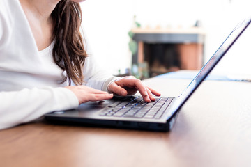 Woman in smart working in front of a laptop typing text during online conference. Smart working activities during quarantine coronavirus covid-2019 pandemic disease in italy. Working at home