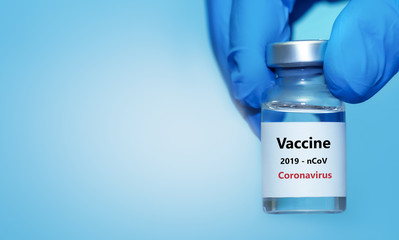 Hand of a doctor or nurse in a glove holds a coronavirus vaccine.The concept of vaccination, medicine, healthcare.