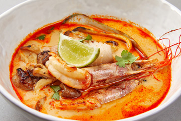 tom yam, shrimp and fish in tomato sauce with herbs and lime , seafood soup