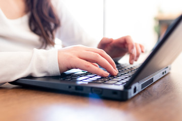 Woman in smart working in front of a laptop typing text during online conference. Smart working activities during quarantine coronavirus covid-2019 pandemic disease in italy. Working at home