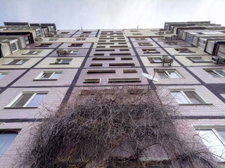 Bottom-up view on facade of old soviet multistorey typical concrete apartment.