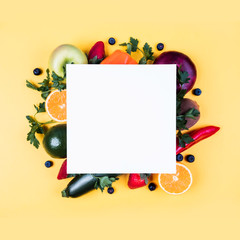 Fruits and vegetables on a yellow background with a white sheet for text