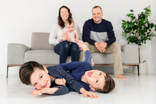 Agitated young boys family at home with the parent sit on sofa