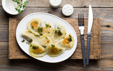 Fried dumplings with herbs on wood.