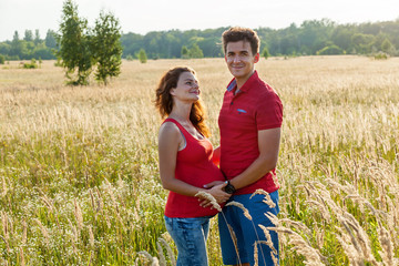 A happy couple is posing in the wheat field