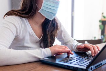 Woman in smart working in front of a laptop typing text during online conference. Smart working activities during quarantine coronavirus covid-2019 pandemic disease in italy. Working at home