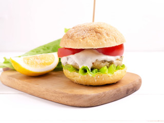 Vegetarian burgers with ready- made cutlets and cashew nut sauce , tomato slice and salad on a white wooden background. Vegan, vegetarian, healthy food, superfood.