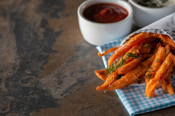 selective focus of french fries with salt near ketchup and garlic sauce on marble surface