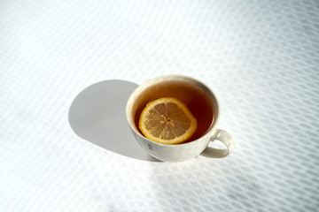 Cup of tea with lemon on white background.