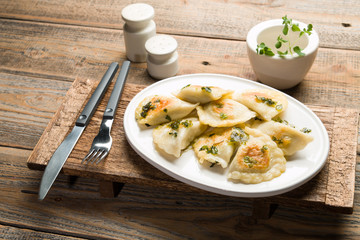 Fried dumplings with herbs on wood.