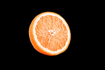 Macro photo of slice of orange fruit isolated on black background
