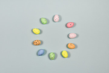 Easter eggs laid out in a circle on a blue background. View from above. The basis for the postcard. Place for an inscription. Easter concept.