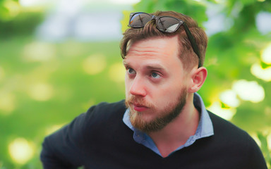 Serious young man with sunglasses at street cafe